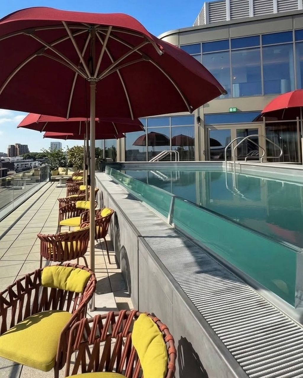 Phase two: Level 9 rooftop pool and terrace at The BoTree, with red parasols and woven loungers
