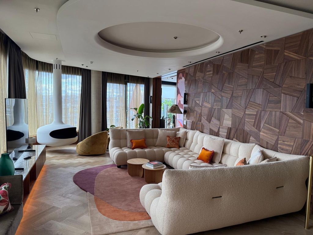 Phase two: Level 8 suite at The BoTree with parquetry walnut wall and curved sofa