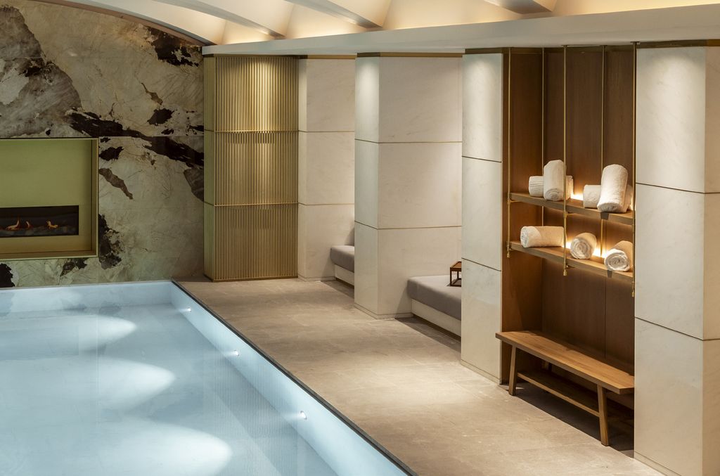 Corinthia Brussels poolside niche with fireplace wall and timber shelving
