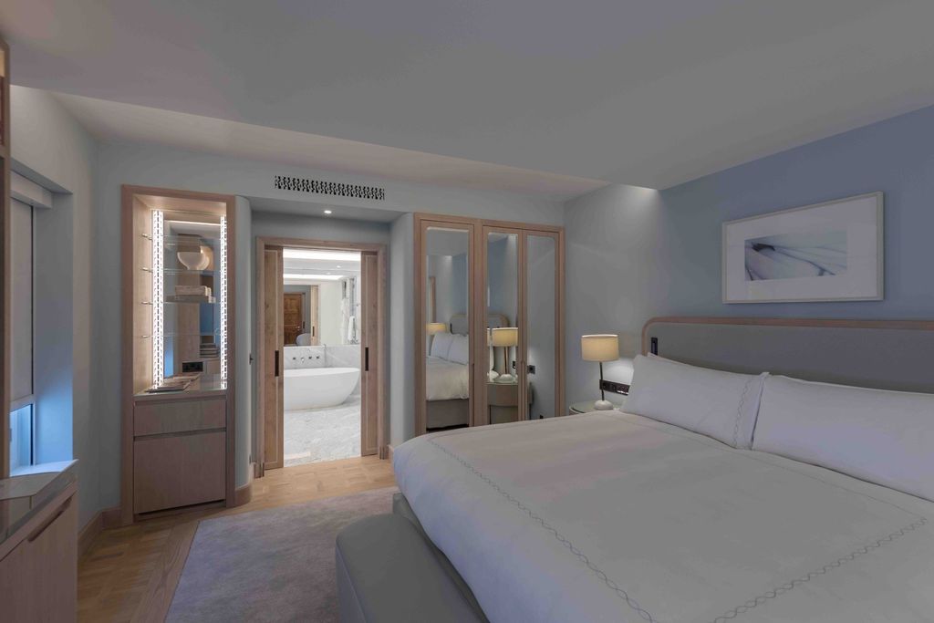 Claridge's guestroom with mirrored joinery and a view through to the marble bathroom