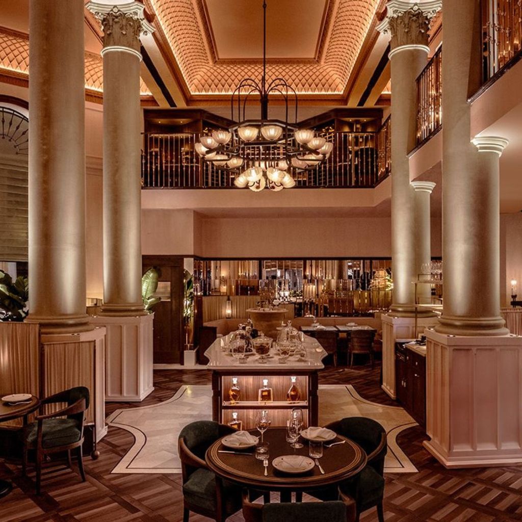 Corinthia London restaurant bar framed by columns beneath a domed ceiling