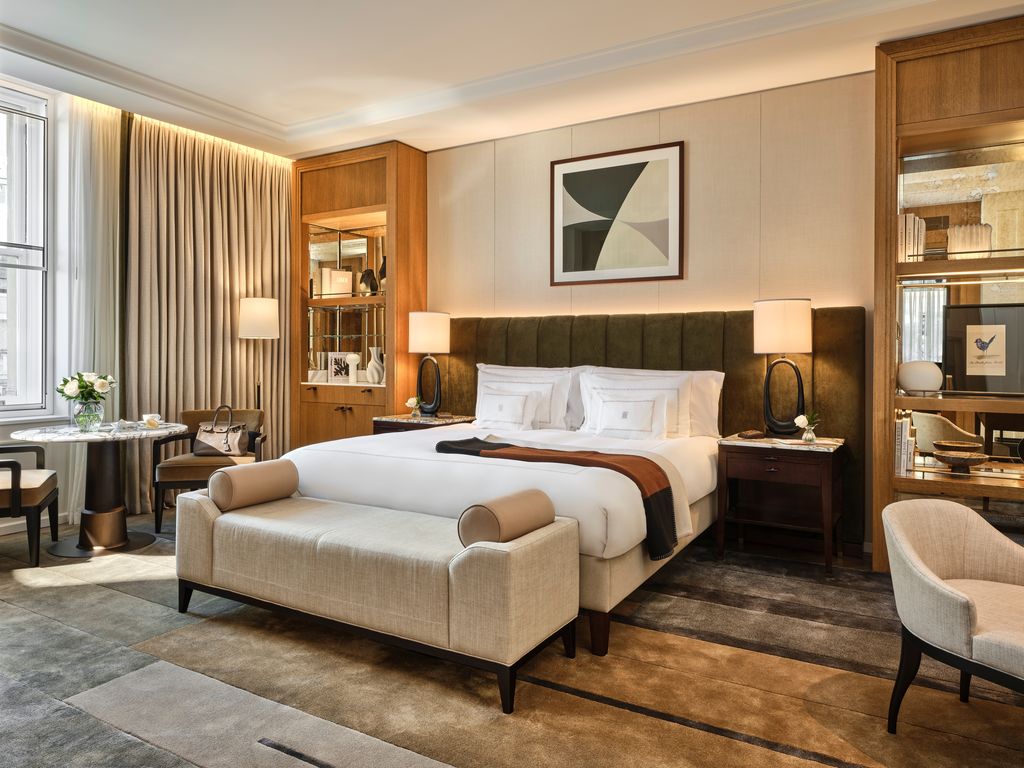 Corinthia London guestroom with upholstered headboard, oak joinery and tall sash windows