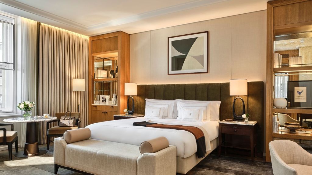 Corinthia London bed wall flanked by lit timber shelving