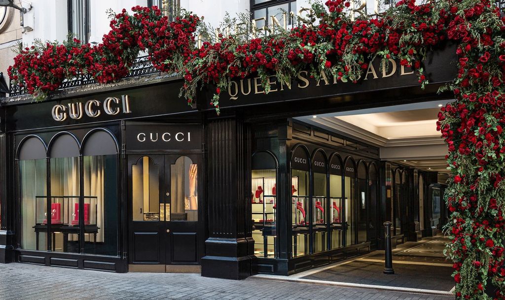 Gucci Belfast façade with red rose garland above arched windows