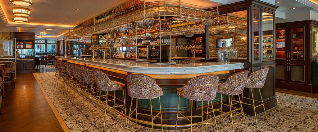 The Mercantile, Dublin: curved marble-topped island bar with brass glass racks, patterned stools and dark timber back bar