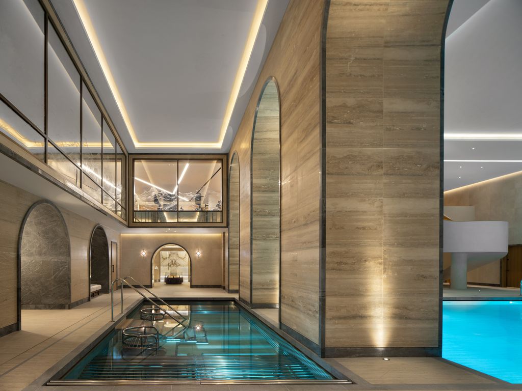 Guerlain Spa pool hall at The OWO with travertine walls and glazed gallery