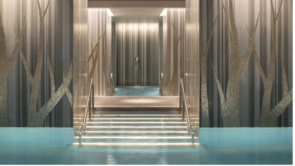 Lit pool steps between tree-motif walls at The Spa, Ten Trinity Square